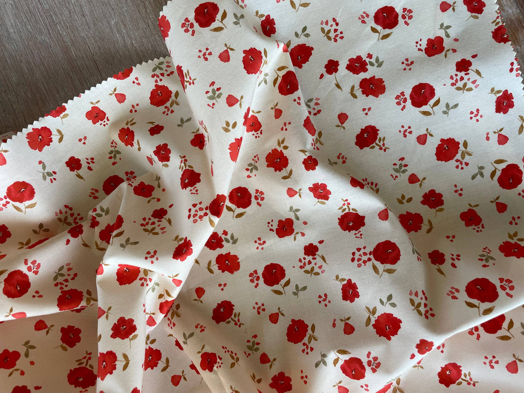 Close-up of Poppy print poplin by Atelier 27 showing botanical detail on vanilla ground