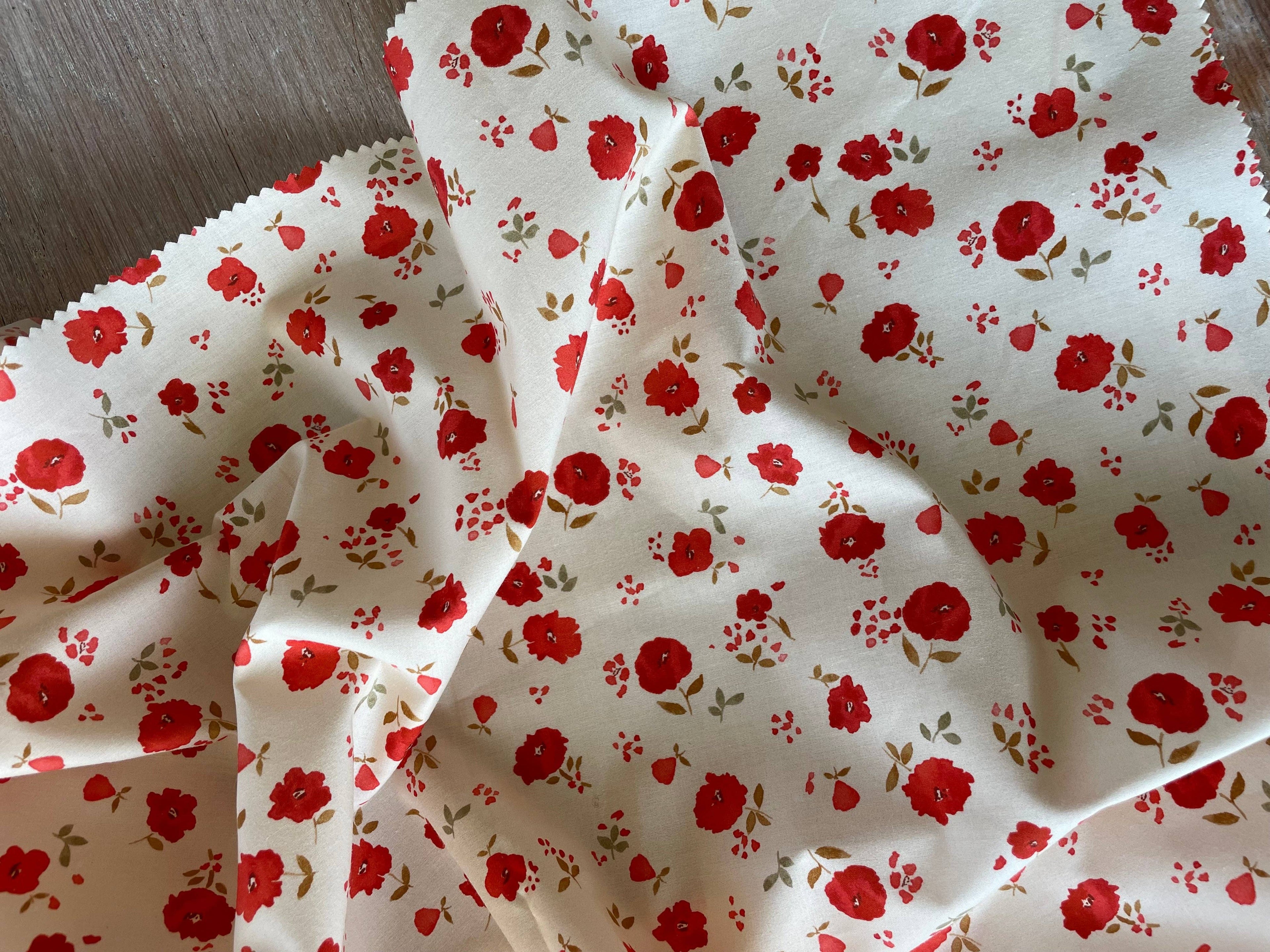 Close-up of Poppy print poplin by Atelier 27 showing botanical detail on vanilla ground