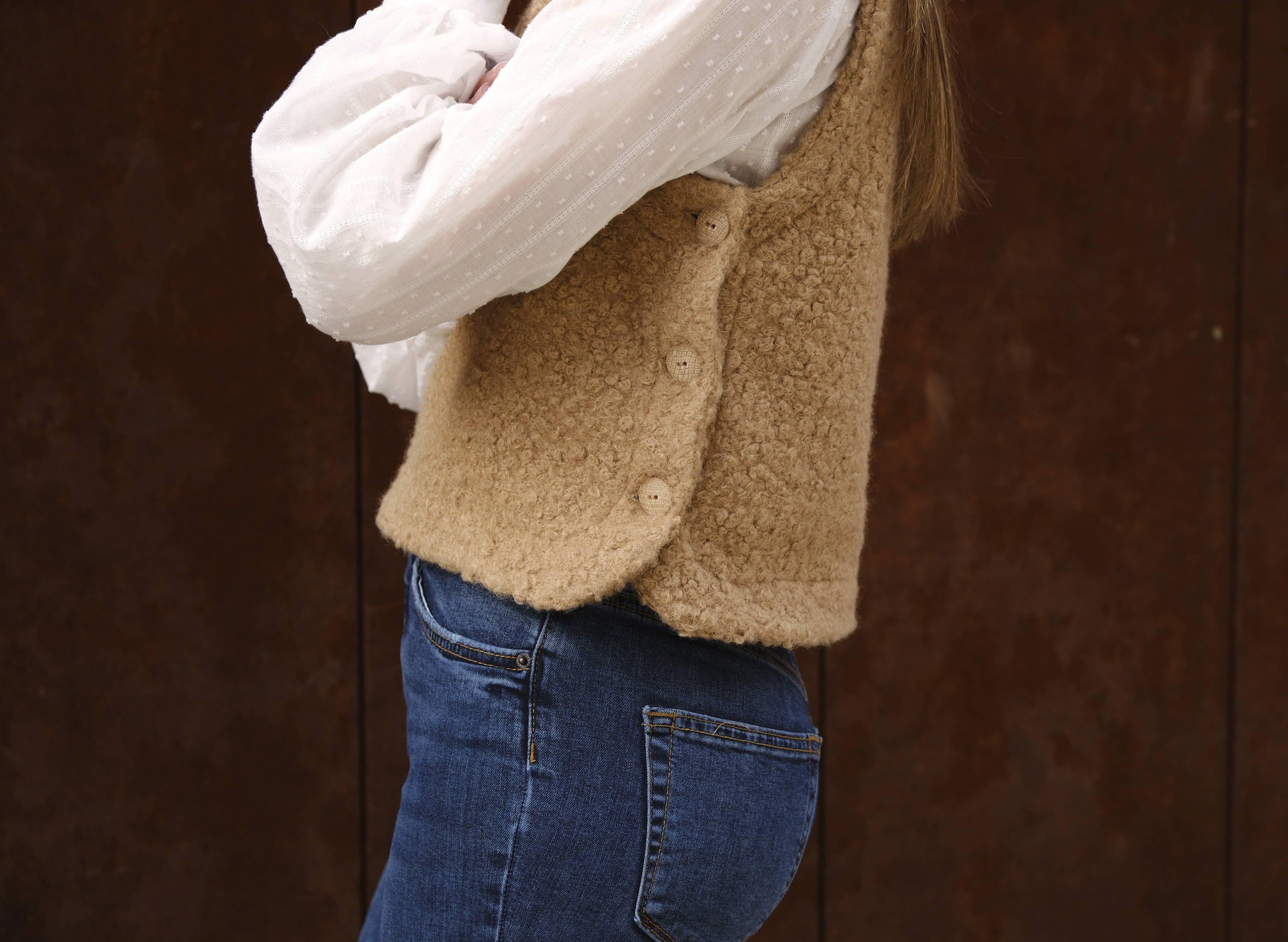 Side detail of the camel bouclé Téva Slipover showing side buttons