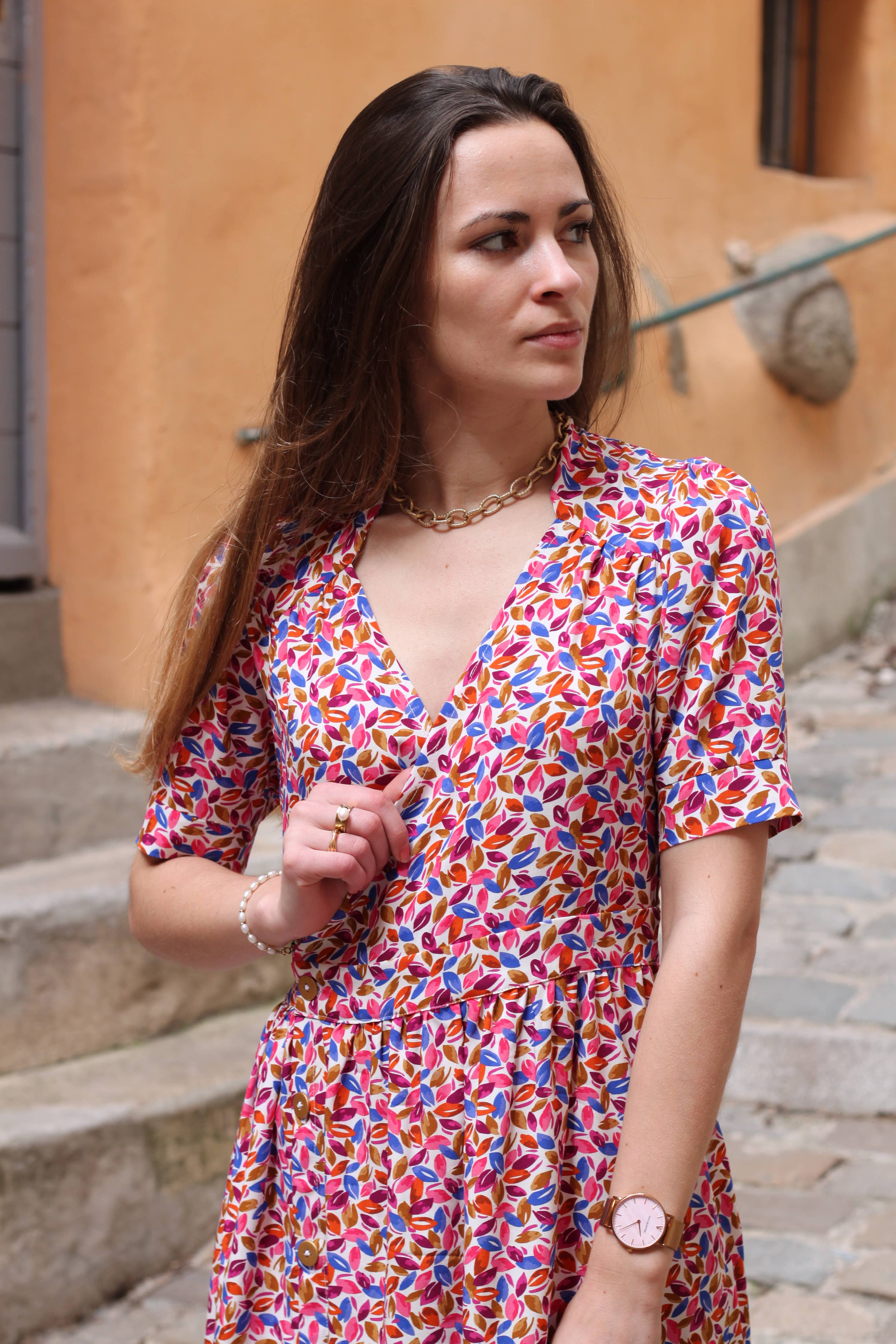 Portrait of the pink floral Garance Dress showing V-neck wrap bodice and cuffed sleeves