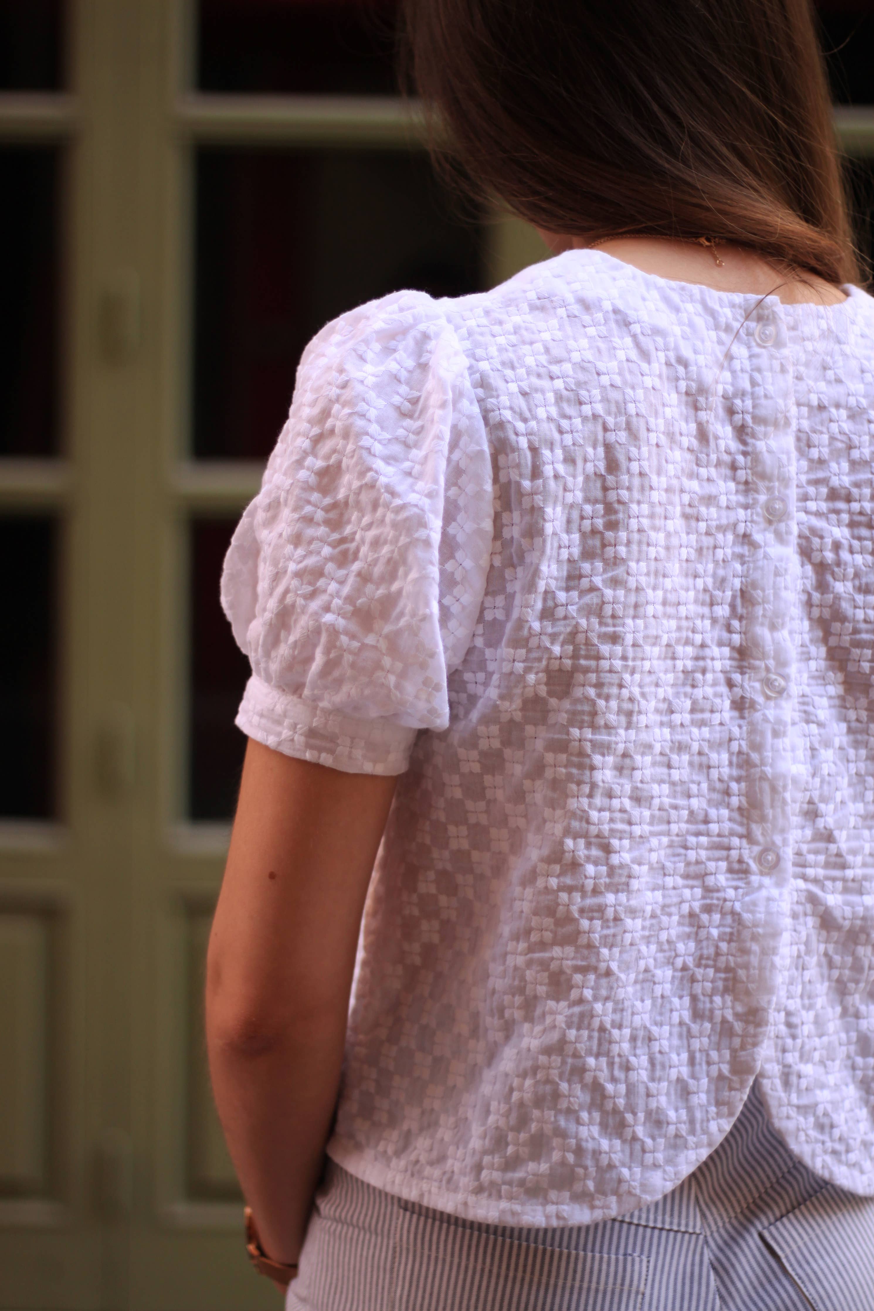 Back view of the white Eléanor Top showing button placket and curved hem