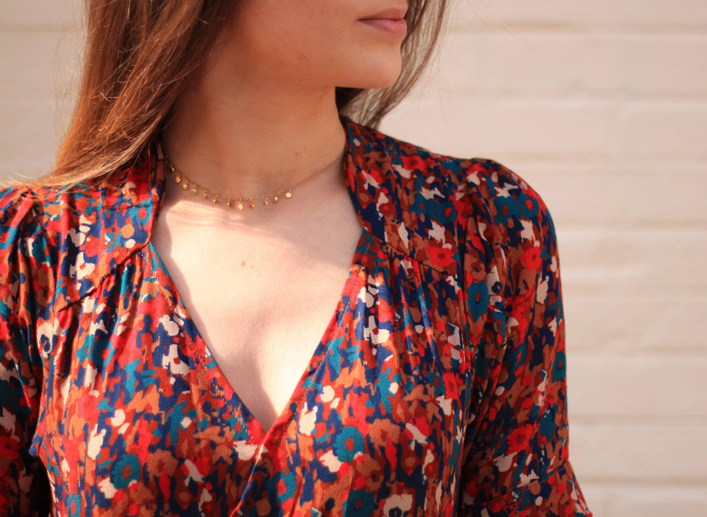 Close-up of the Garance Dress wrap bodice and gathered shoulder yoke in rust floral fabric