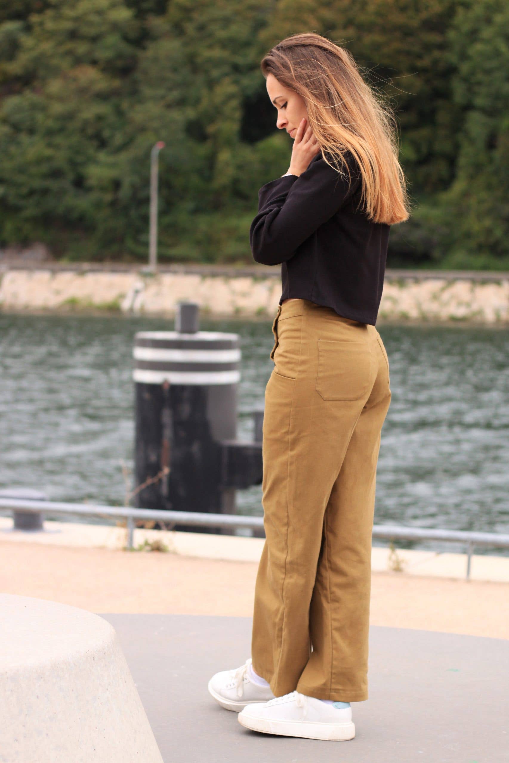 Side view of the camel Thaïs high-waisted trousers with white sneakers