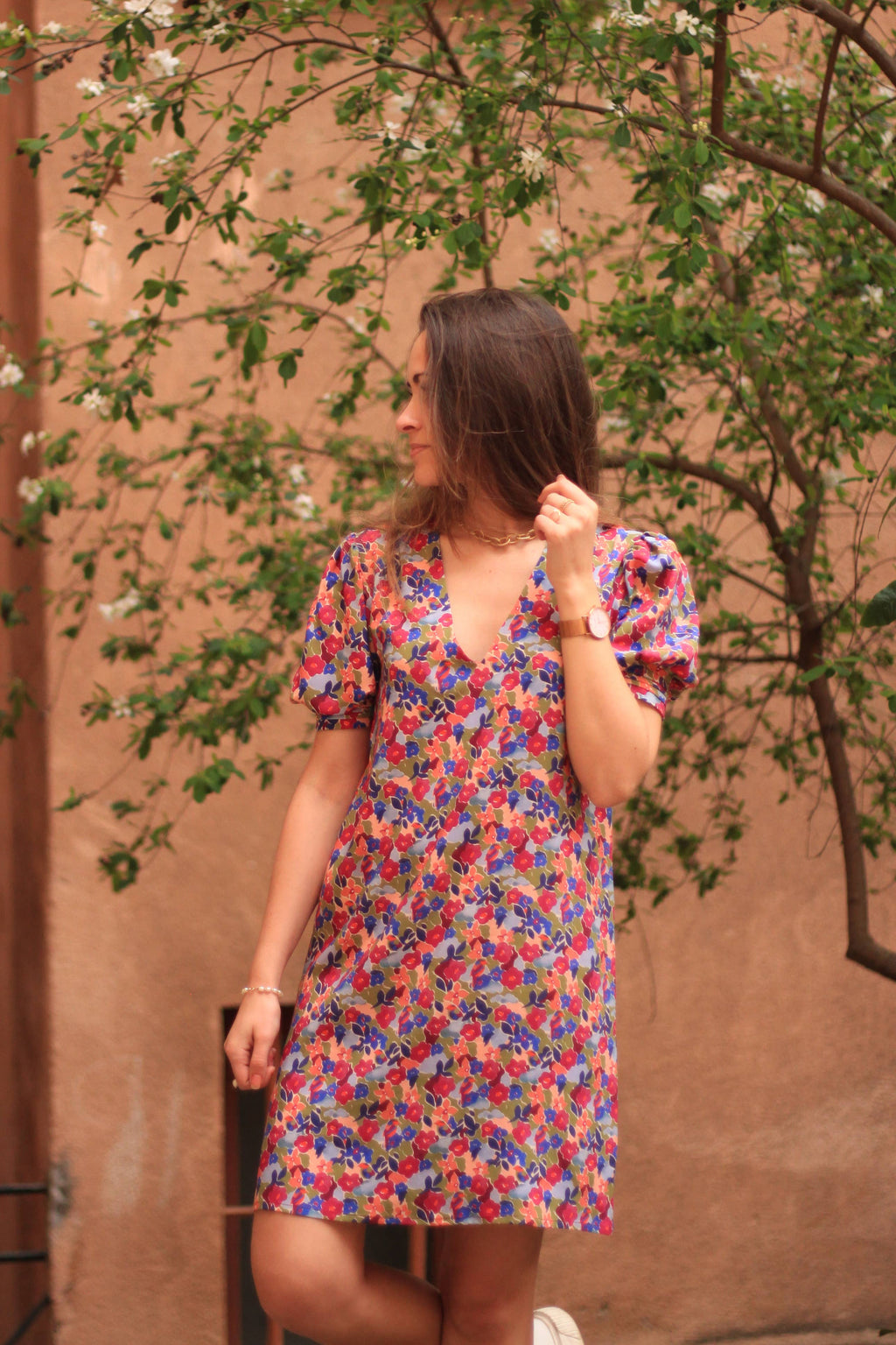 Front view of the floral Calie V-neck shift dress under a tree