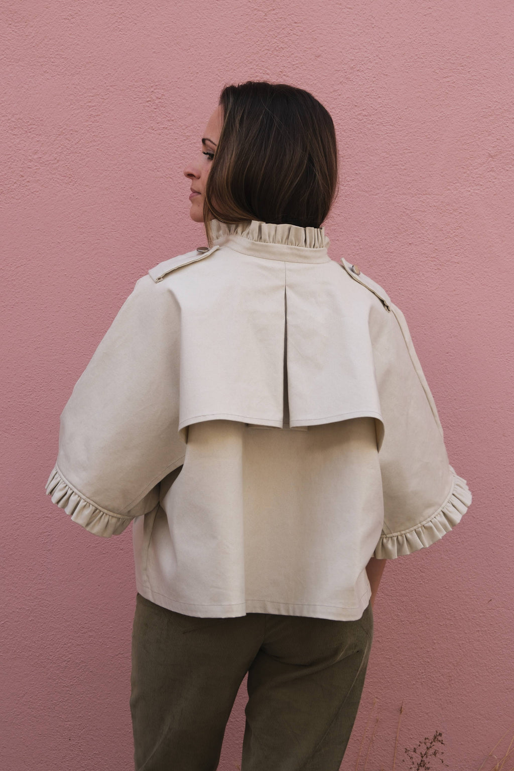 Back view of the cream Alixia Trench Coat showing back vent and ruffle collar