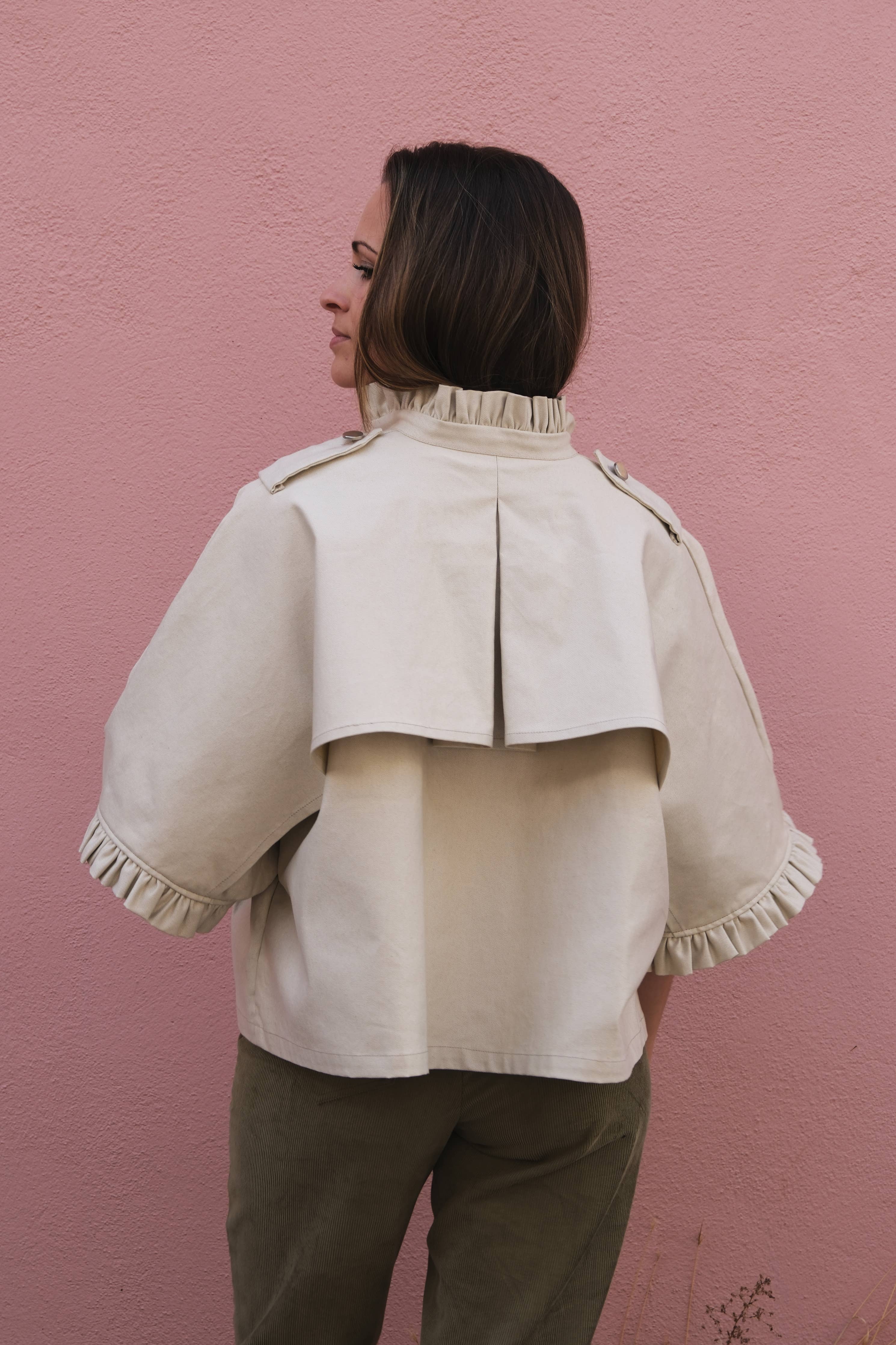 Back view of the cream Alixia Trench Coat showing back vent and ruffle collar