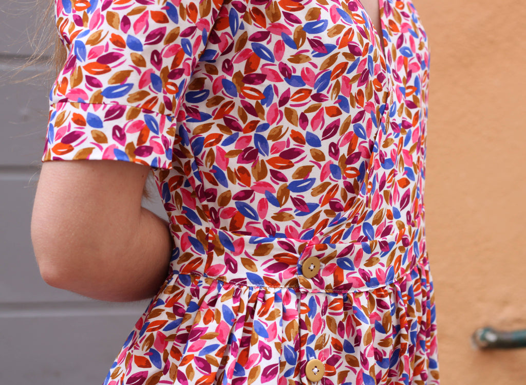 Detail of the Garance Dress gathered waist and cuffed sleeve in multicolour print