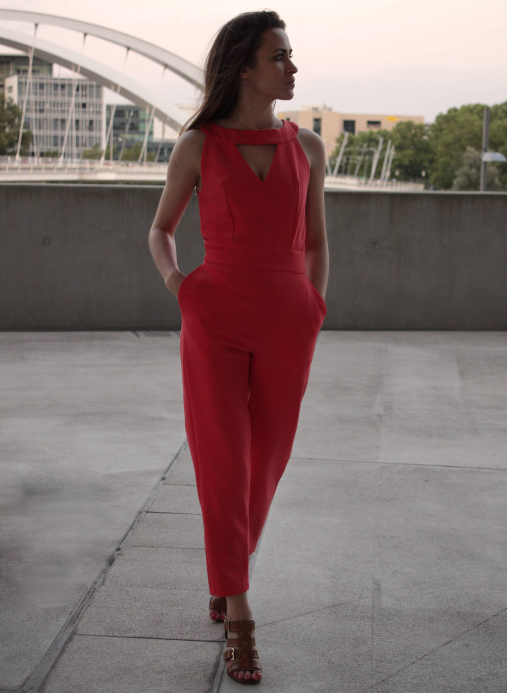 Red Aurore Jumpsuit with keyhole neckline and inseam pockets, front view on a terrace