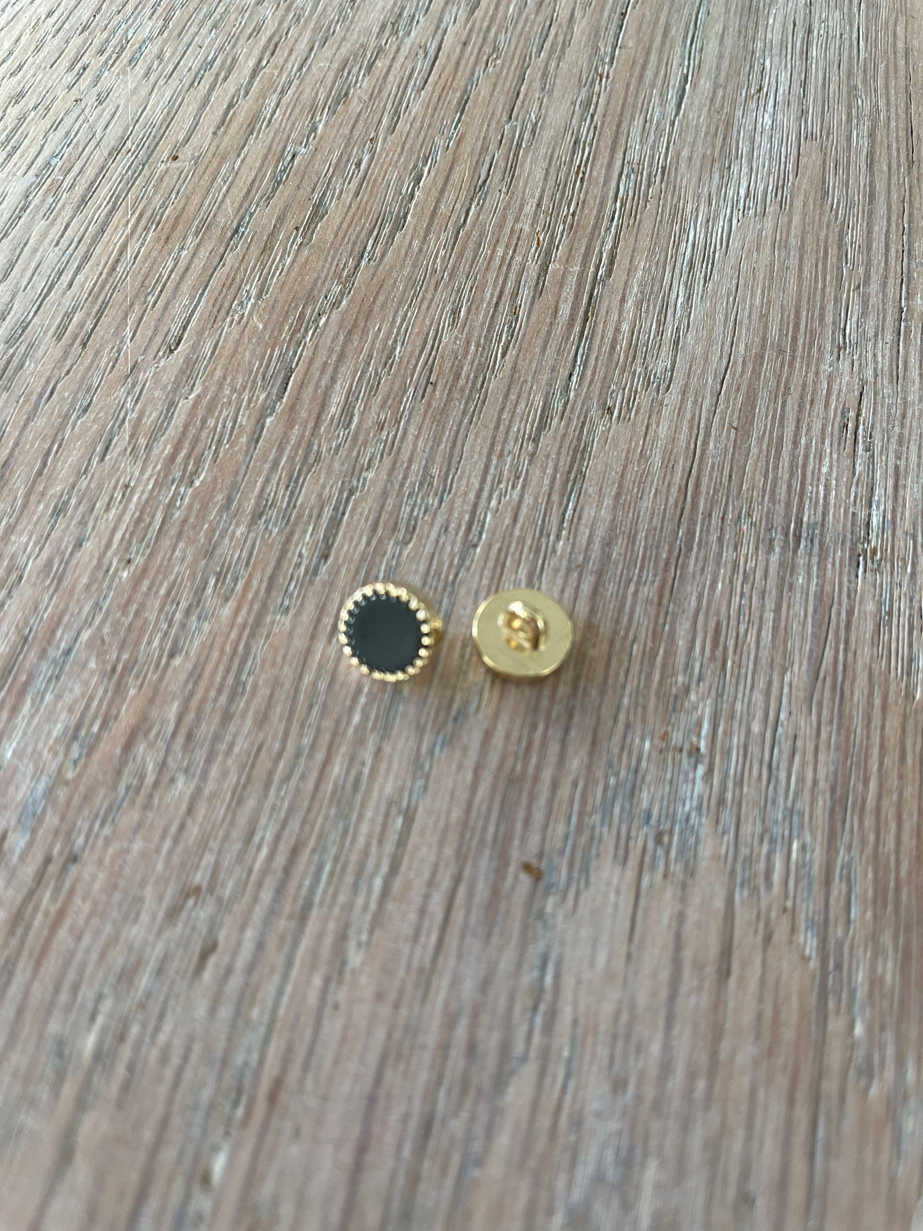 Close-up of Atelier 27 Adorable button showing gold zamack and black hot enamel detail