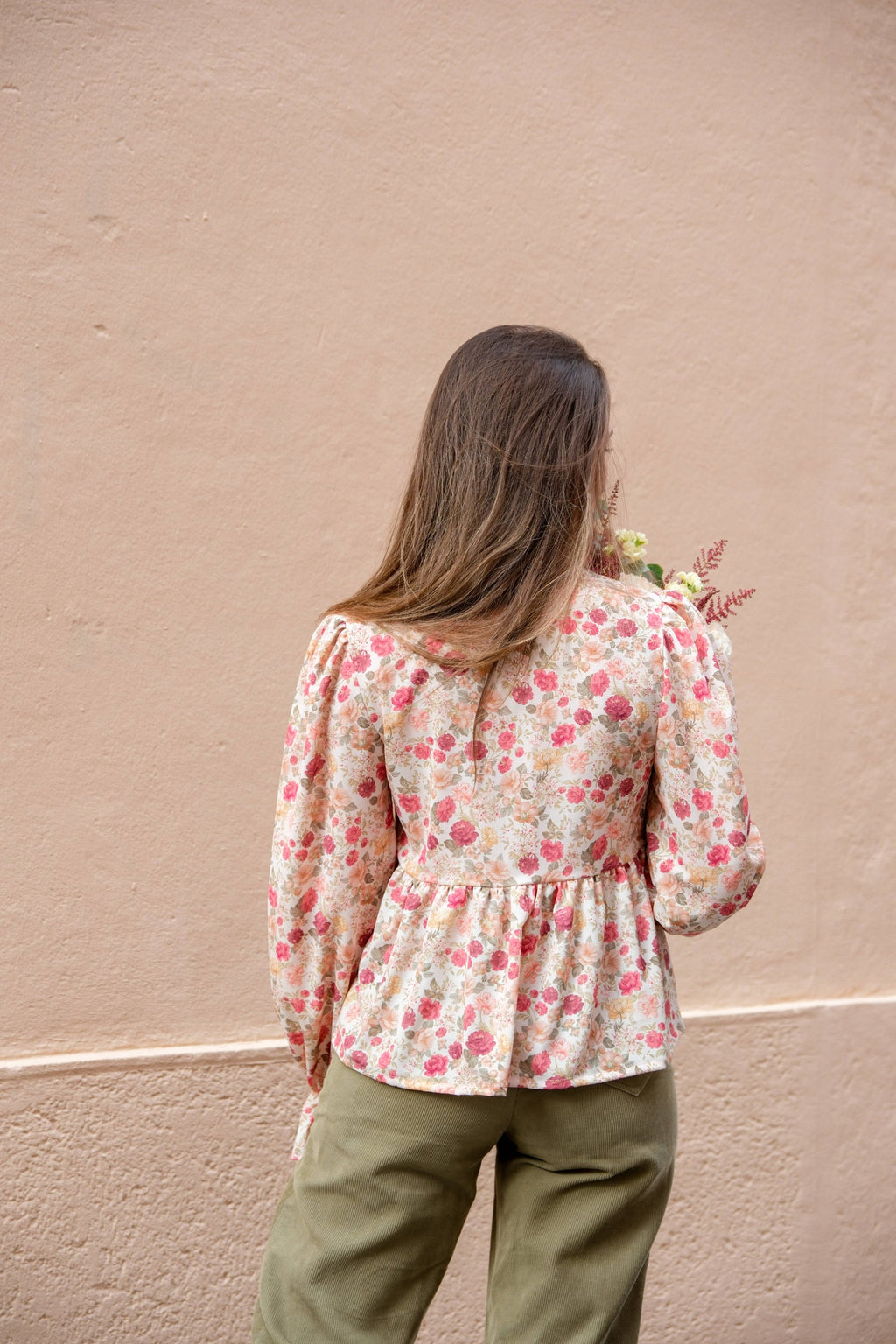 Back view of the floral Alessia Blouse showing gathered hip tier and full sleeves