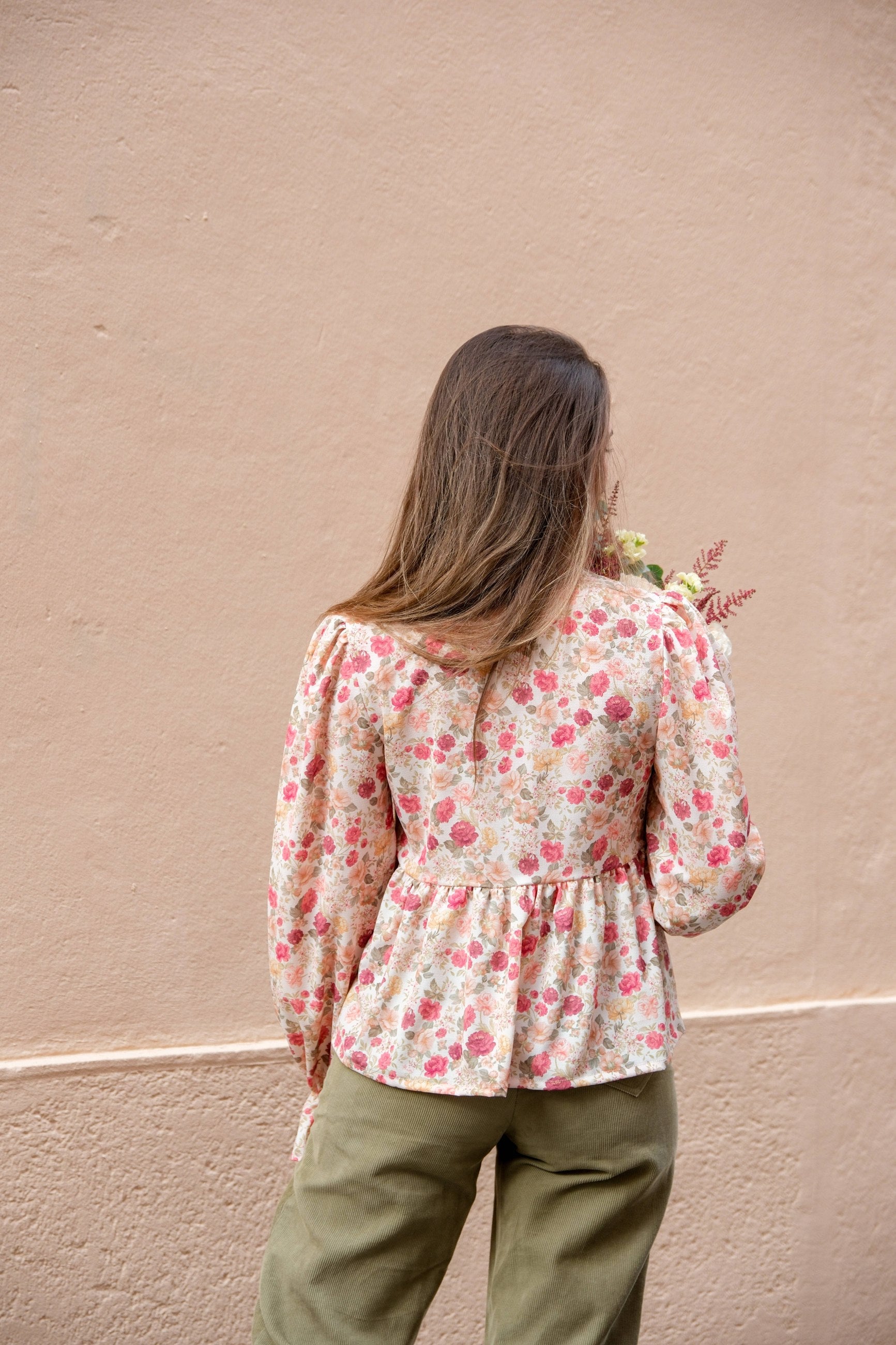 Back view of the floral Alessia Blouse showing gathered hip tier and full sleeves