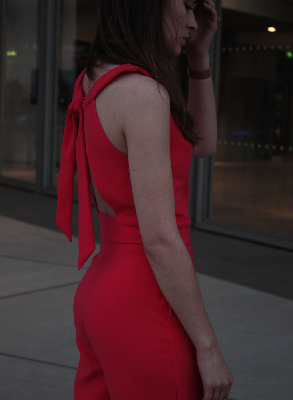 Close-up of the Aurore Jumpsuit back bow tie in red fabric