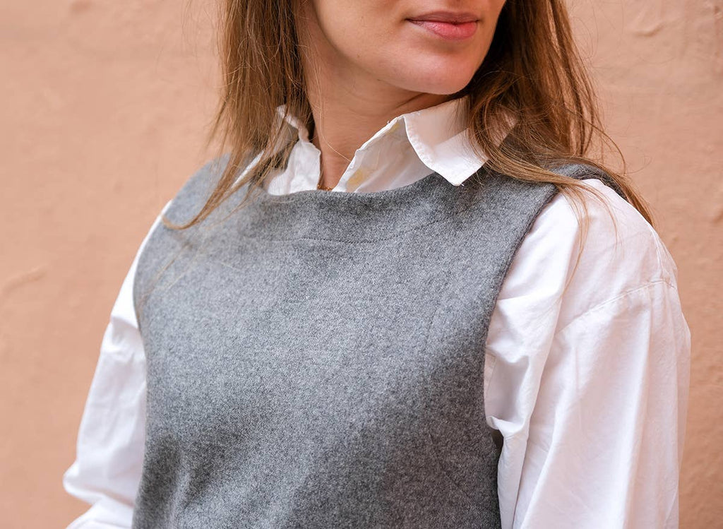 Close-up of the grey Téva Slipover neckline and shoulder over a white shirt collar