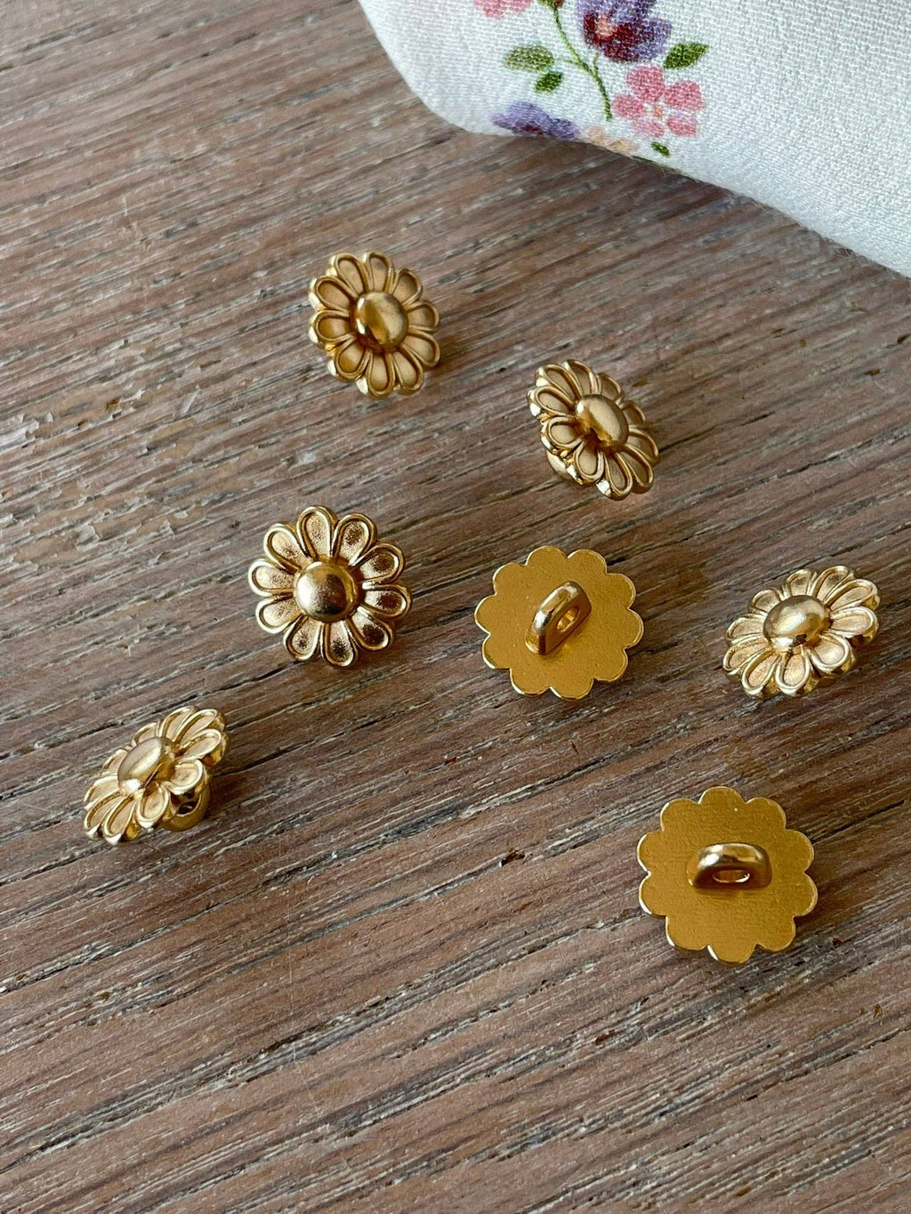 Close-up of La Chicorée floral gold button by Atelier 27 showing petal detail