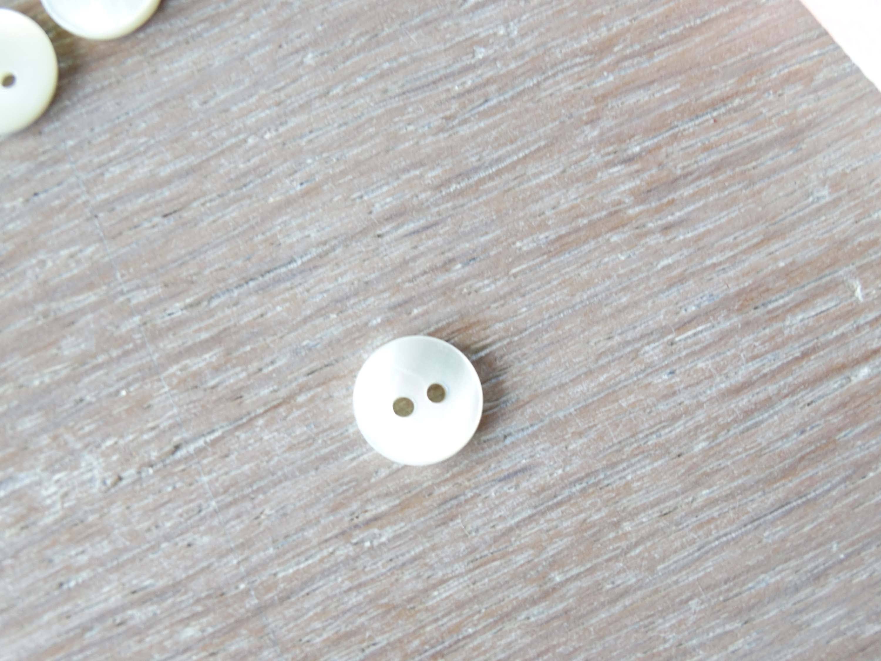 Close-up of Atelier 27 ivory pearlescent button showing natural nacre iridescence