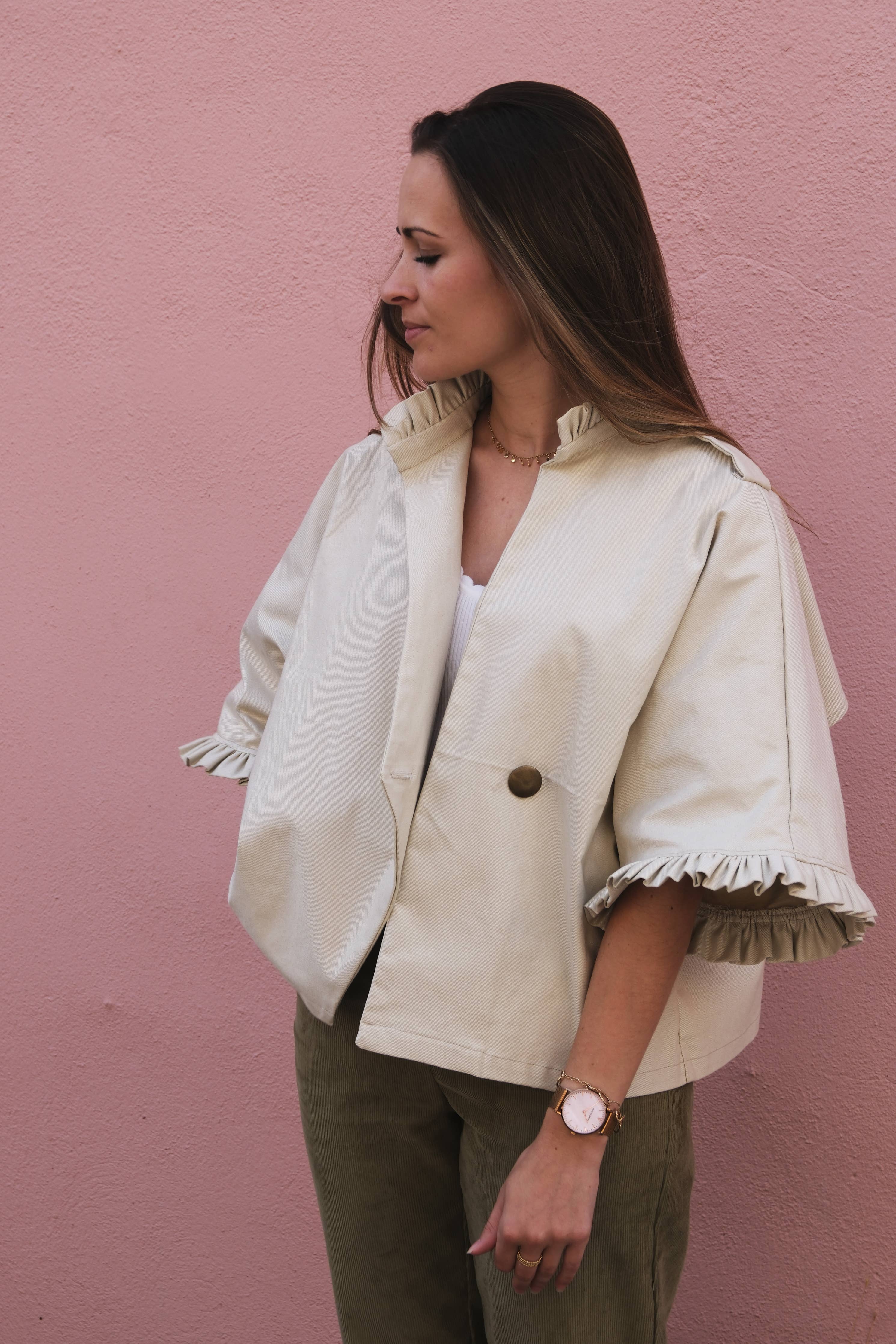 Side view of the cream Alixia short trench coat showing ¾ ruffle sleeves