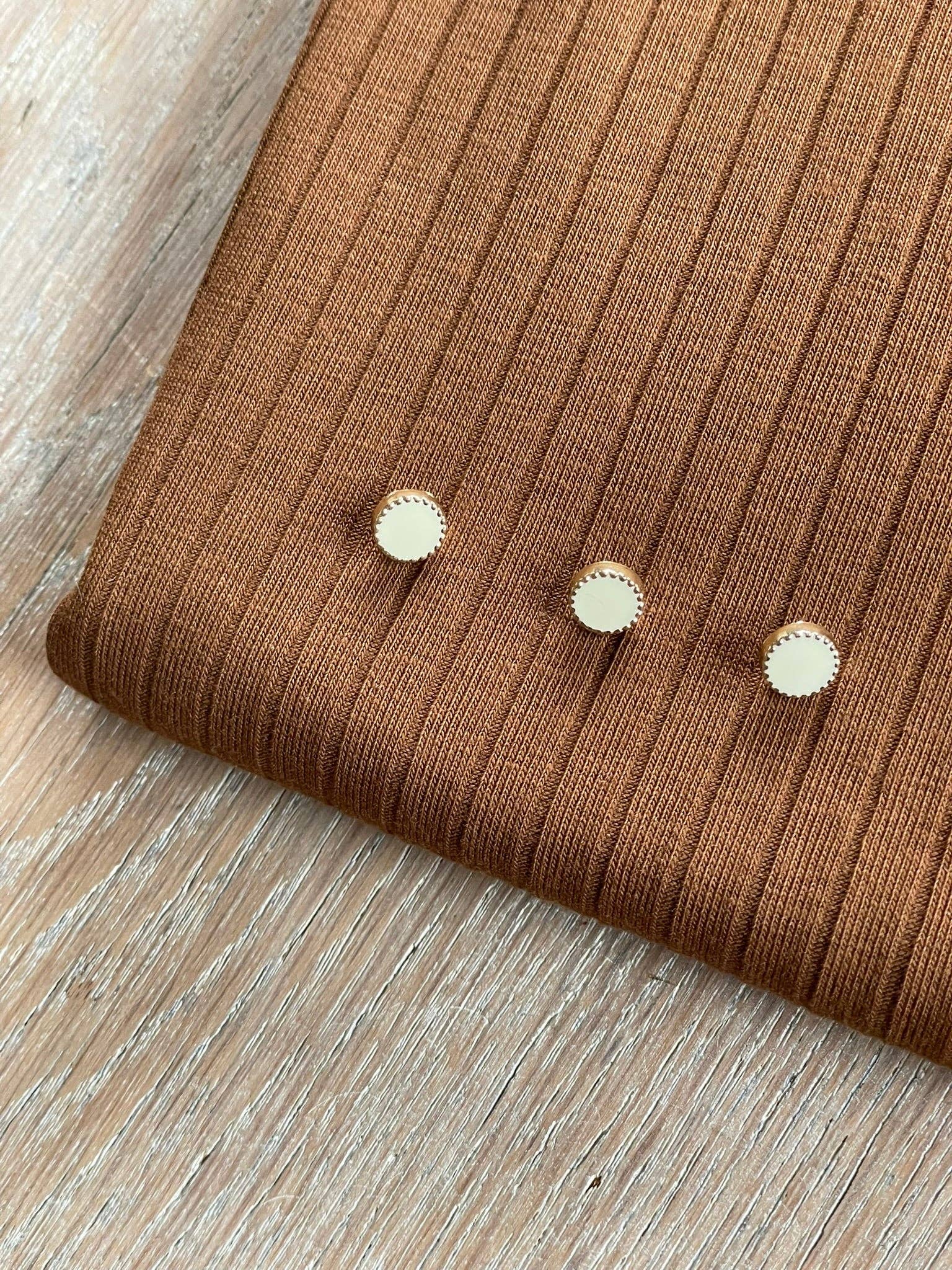 Close-up of Atelier 27 Adorable button showing gold zamack and ivory hot enamel detail