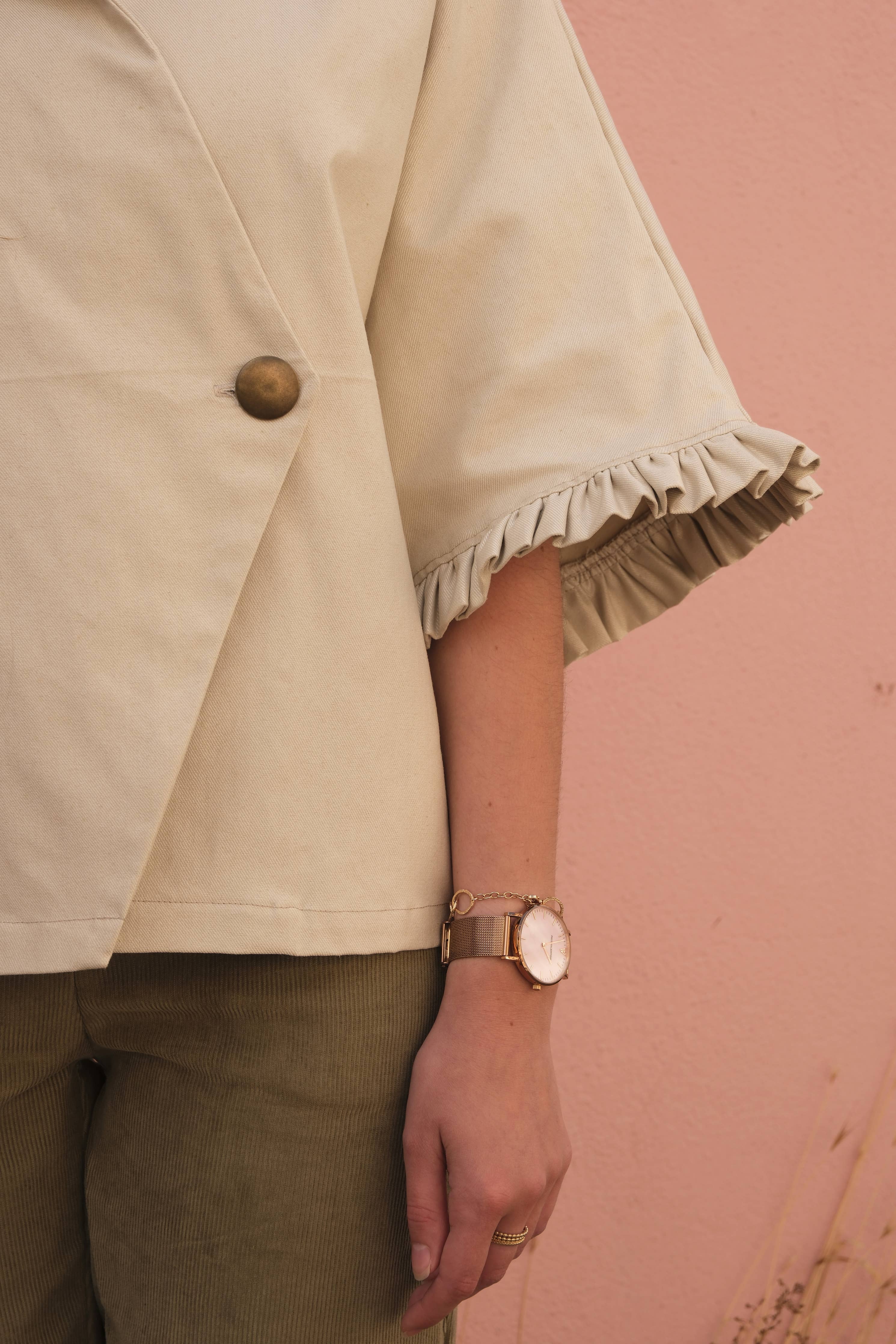 Detail of the Alixia Trench Coat ruffle-trimmed sleeve in cream fabric
