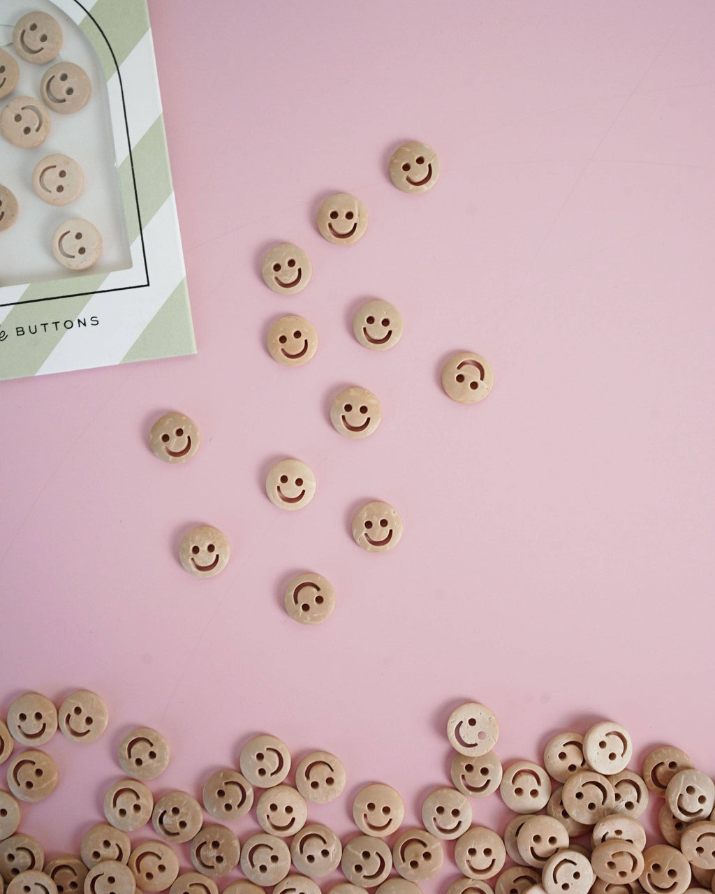 Wooden smiley face buttons showing natural grain, detail view